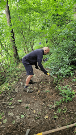 Hard at work with a mattock, digging out a portion of the trail.